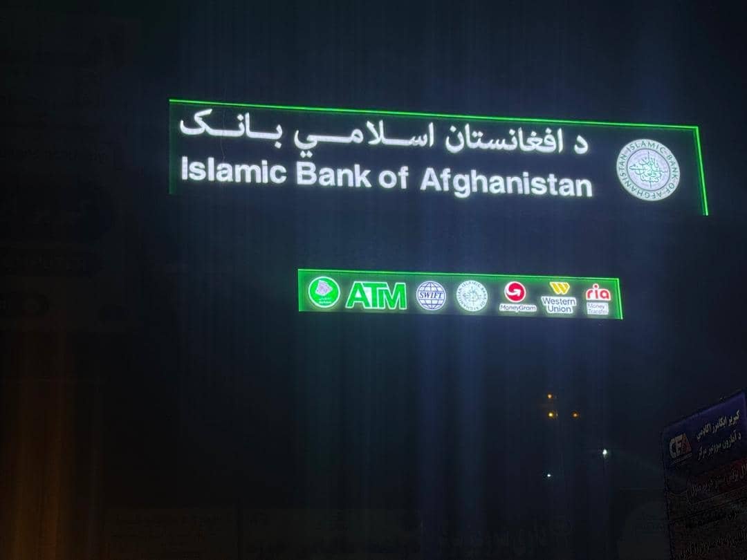 Islamic Bank of Afghanistan illuminated sign with partner service logos at night